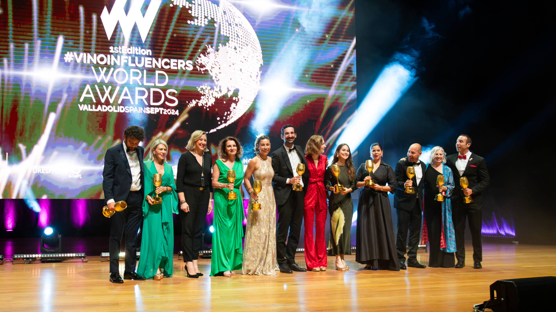 Galardonados de los premios de Vinoinfluencers World Awards con sus premios y en el estrado