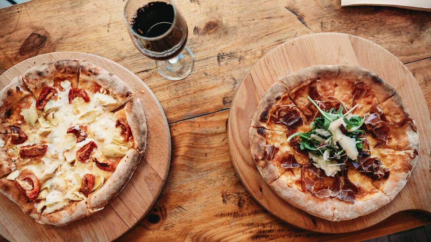 Pizza y vino, a priori puede parecerte una locura, pero te aseguramos que funciona.